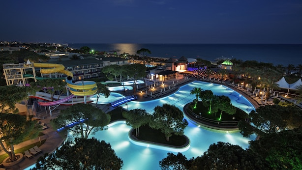 Ein Resort mit großem Pool, Wasserrutschen und Blick auf den Strand.