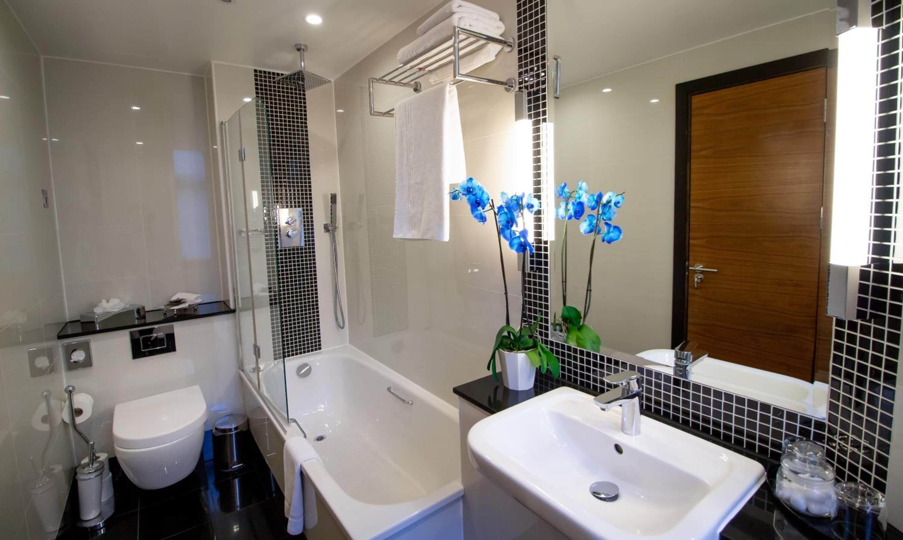 A modern bathroom with a bathtub, a toilet, a sink, and a shower.