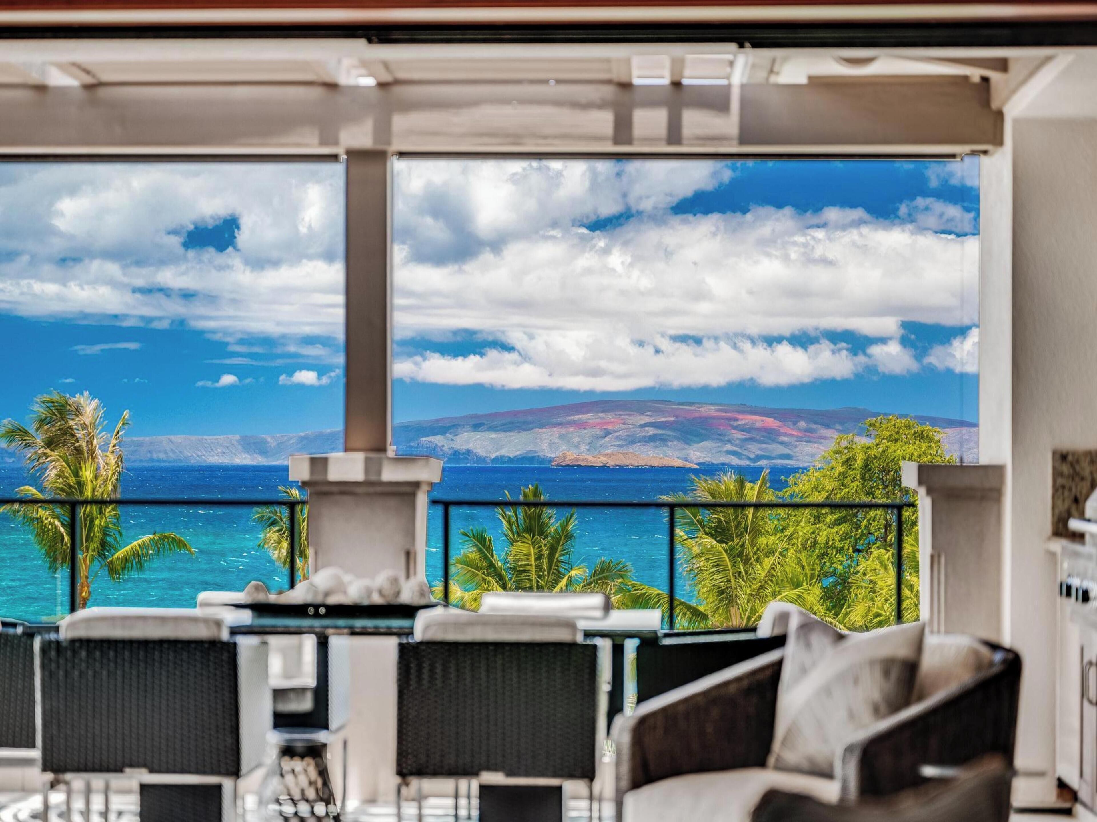 Un balcón con vista al océano y una cordillera.