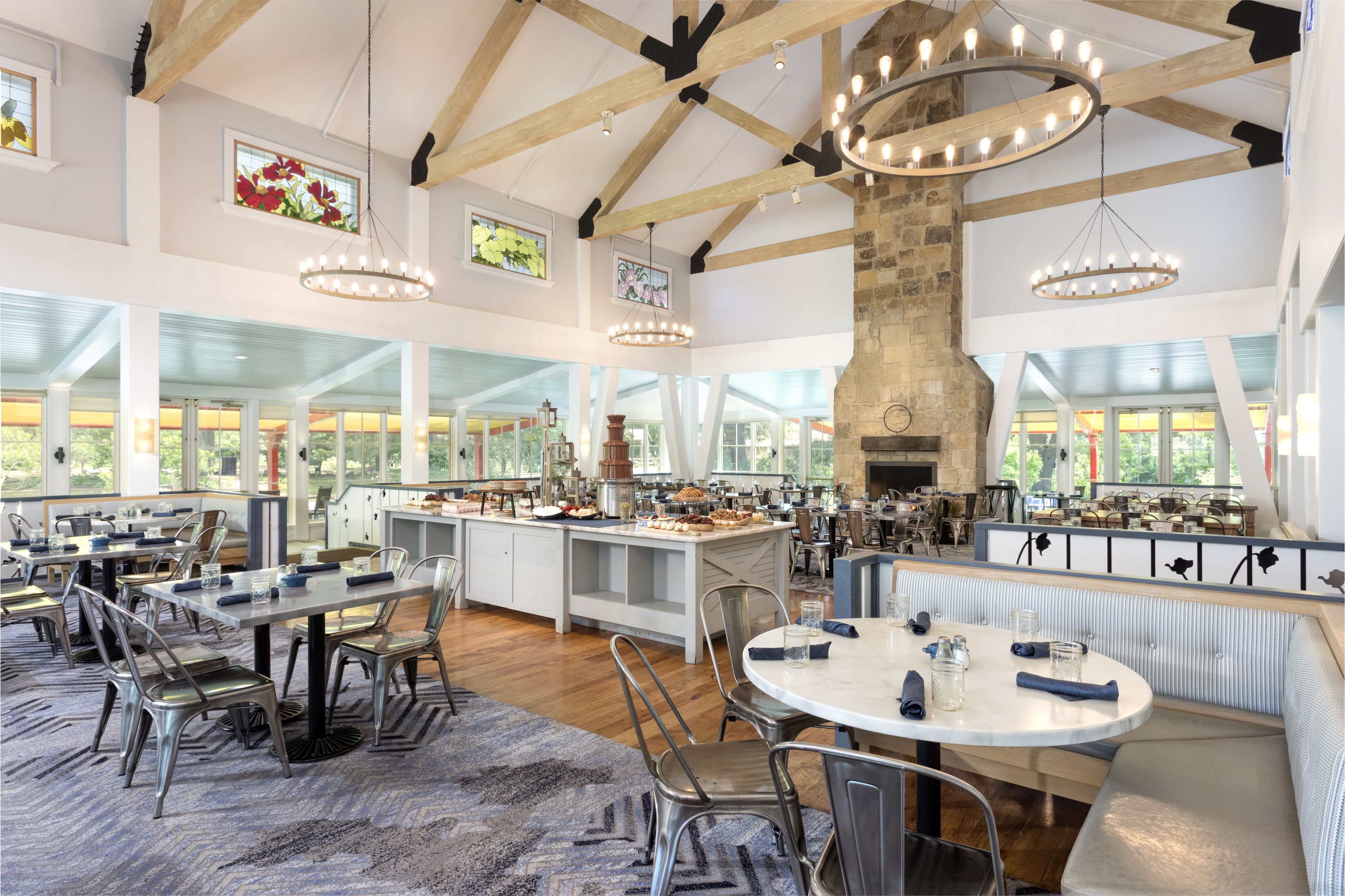 A spacious dining area with high ceilings, exposed wooden beams, and large windows.