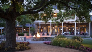 A building with a stone facade, outdoor seating, and a fire feature.