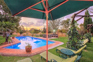 Una piscina al aire libre, sombrillas, tumbonas