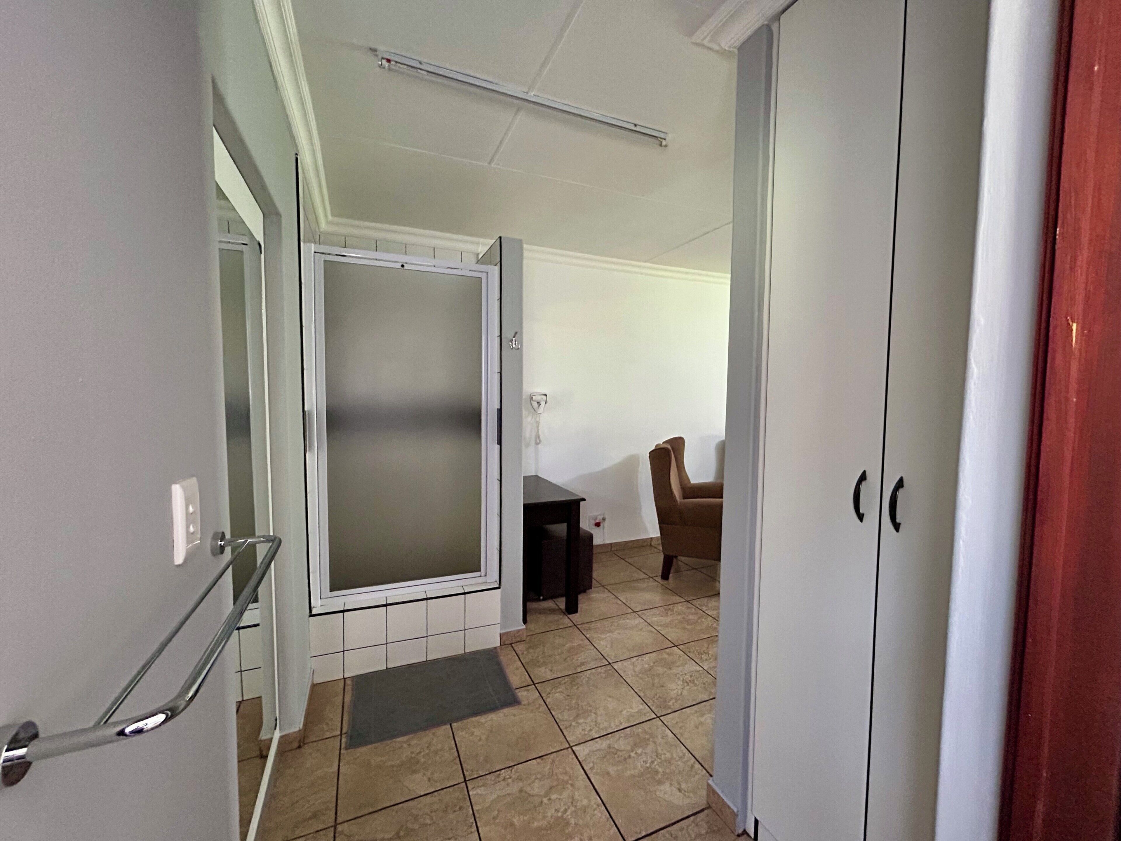 A hallway with a door, a chair, and a small table.