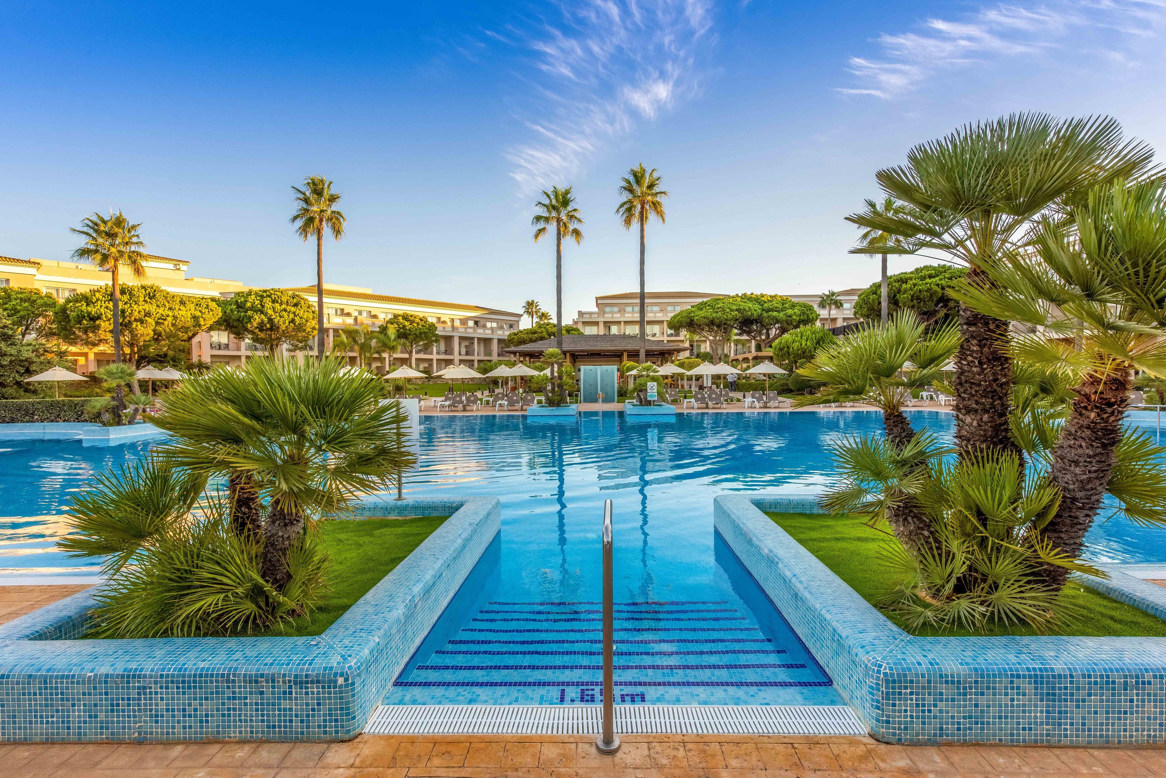 Alberca techada, 2 albercas al aire libre y sombrillas en la alberca