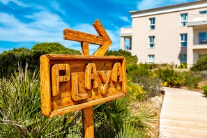 På stranden, hvidt sand, liggestole, parasoller