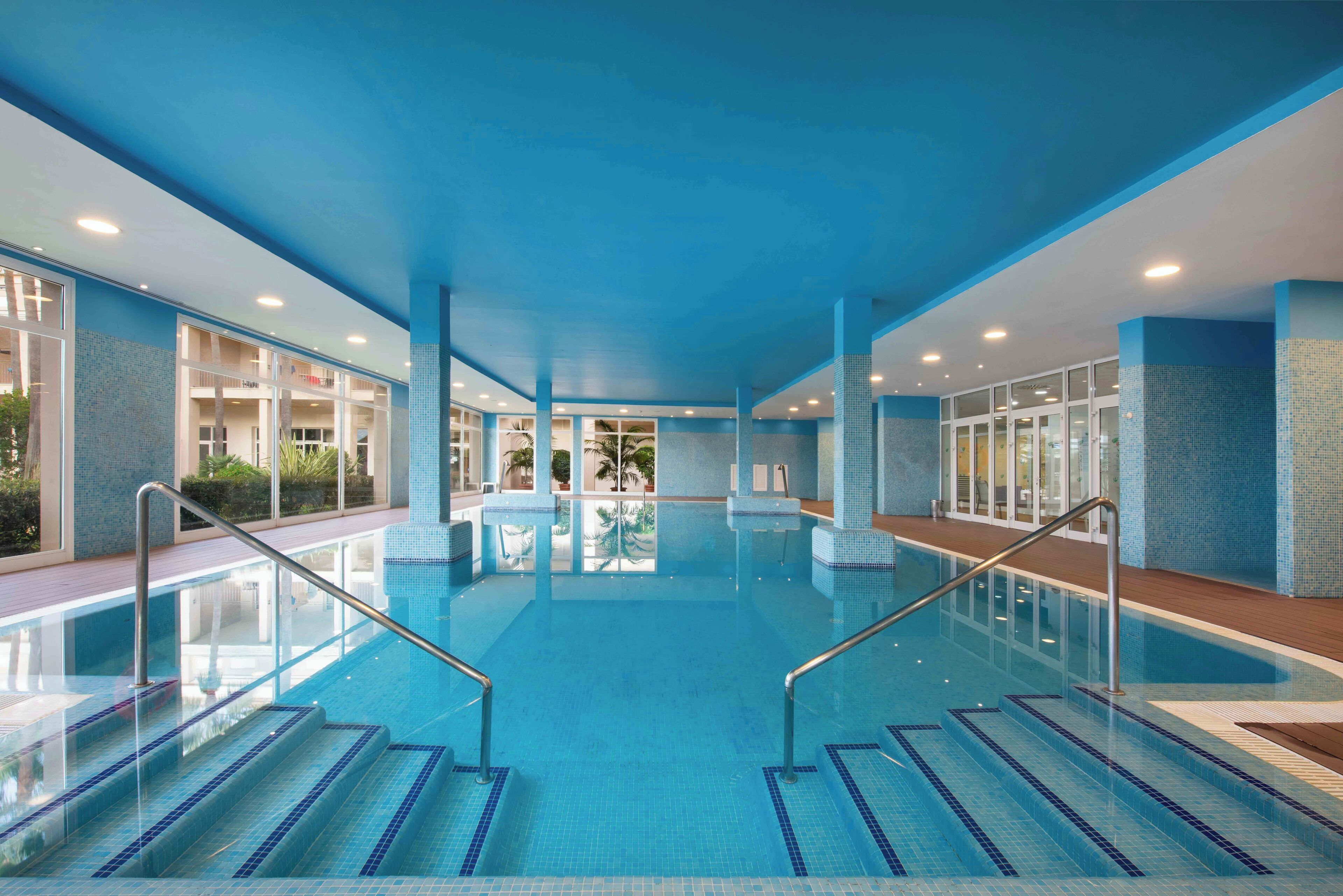 Ein Innenpool mit klarem, blauem Wasser, gefliesten Wänden und modernem Design.