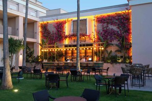 An outdoor bar area with wicker furniture and a well-lit interior. - Valentin Sancti Petri (Chiclana de la Frontera)