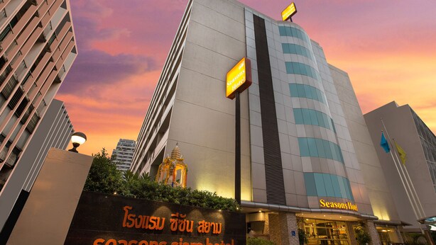 Seasons Siam Hotel with a modern design, a prominent entrance, and a sign in both English and Thai. - Seasons Siam Hotel (Bangkok)