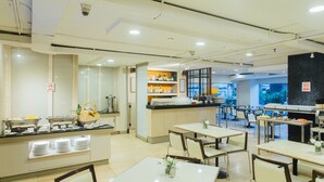 A modern restaurant with a buffet area, multiple dining tables, and a bar. - Seasons Siam Hotel (Bangkok)