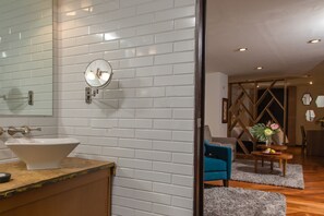 A modern bathroom with white subway tiles, a round mirror, and a white sink.