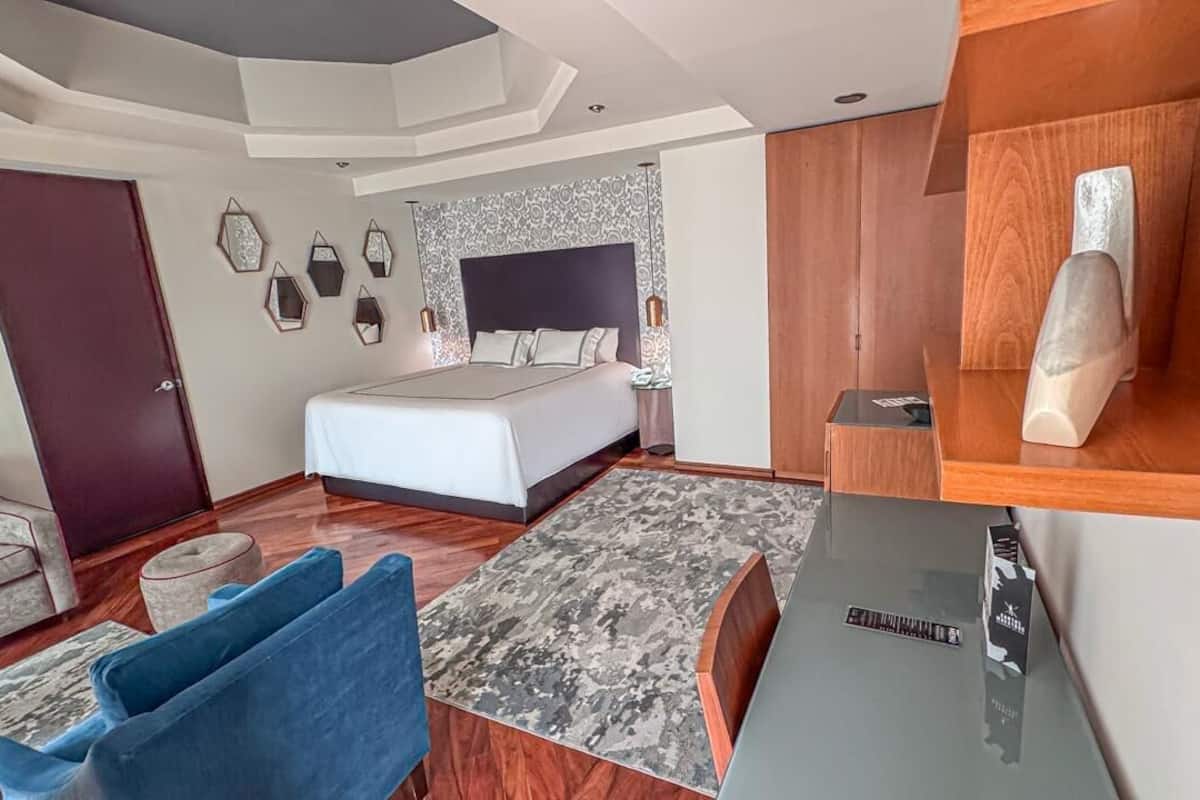 Une chambre moderne comprenant un lit, un bureau, une chaise et une armoire.