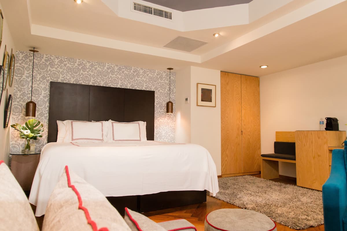 Une chambre moderne avec un grand lit, un bureau et une armoire.