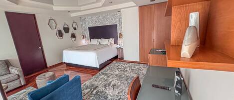 Una habitación de hotel moderna con una cama grande, un escritorio, una silla y un pequeño rincón de descanso.