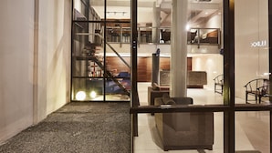 A modern interior with a staircase, seating area, and a reception desk. - Luxx at Silom (Bangkok)