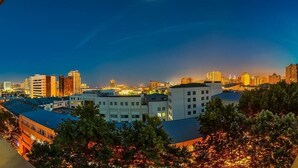 A cityscape at dusk with buildings and trees.