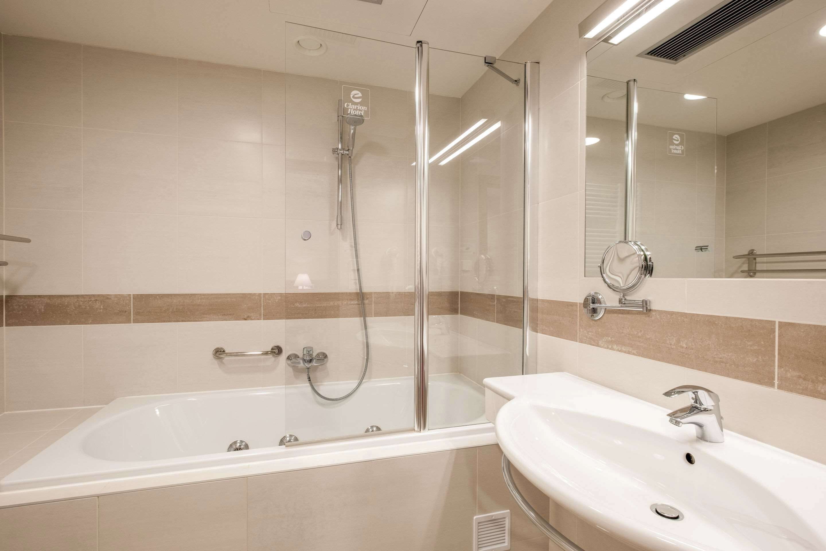 A modern bathroom with a glass-enclosed shower, a standalone bathtub, and a sink with a mirror.
