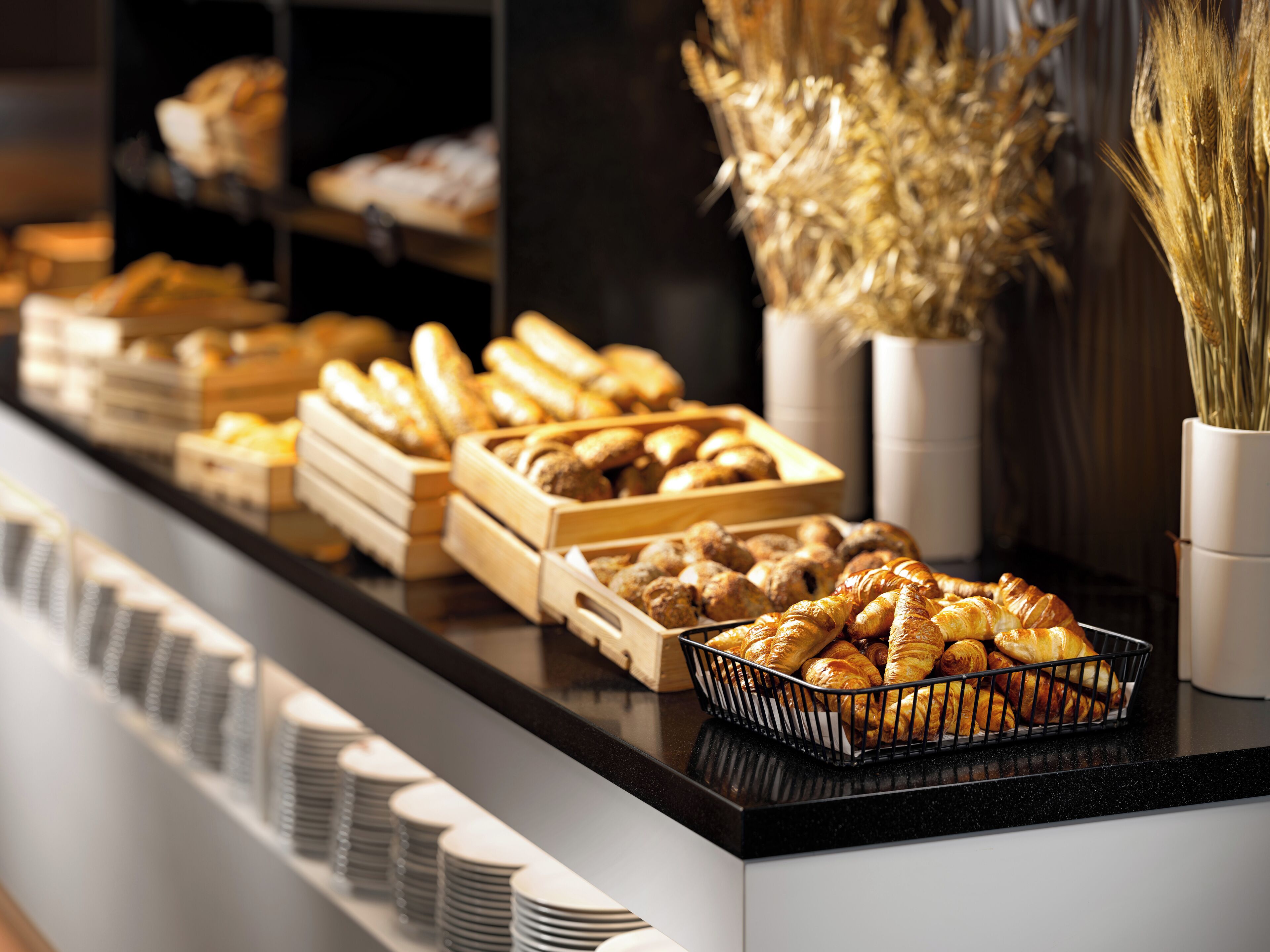 A buffet counter with various baked goods and pastries.