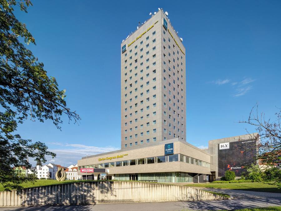 A tall hotel building with a modern design, a prominent entrance, and a clear sky.