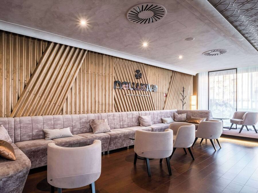 A modern reception area with a wooden slat wall, a plush seating area, and a large window providing natural light.