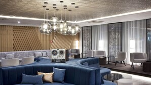 A modern lounge area with a blue sofa, white chairs, and a small table. - Clarion Congress Hotel Ceske Budejovice (Ceske Budejovice)