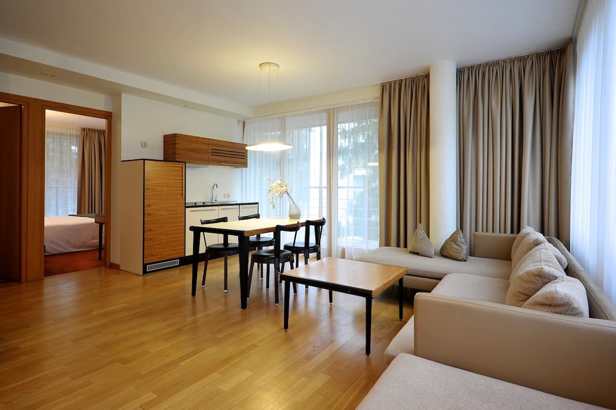 Ein modernes Wohnzimmer mit Sofa, Esstisch und Küchenbereich.