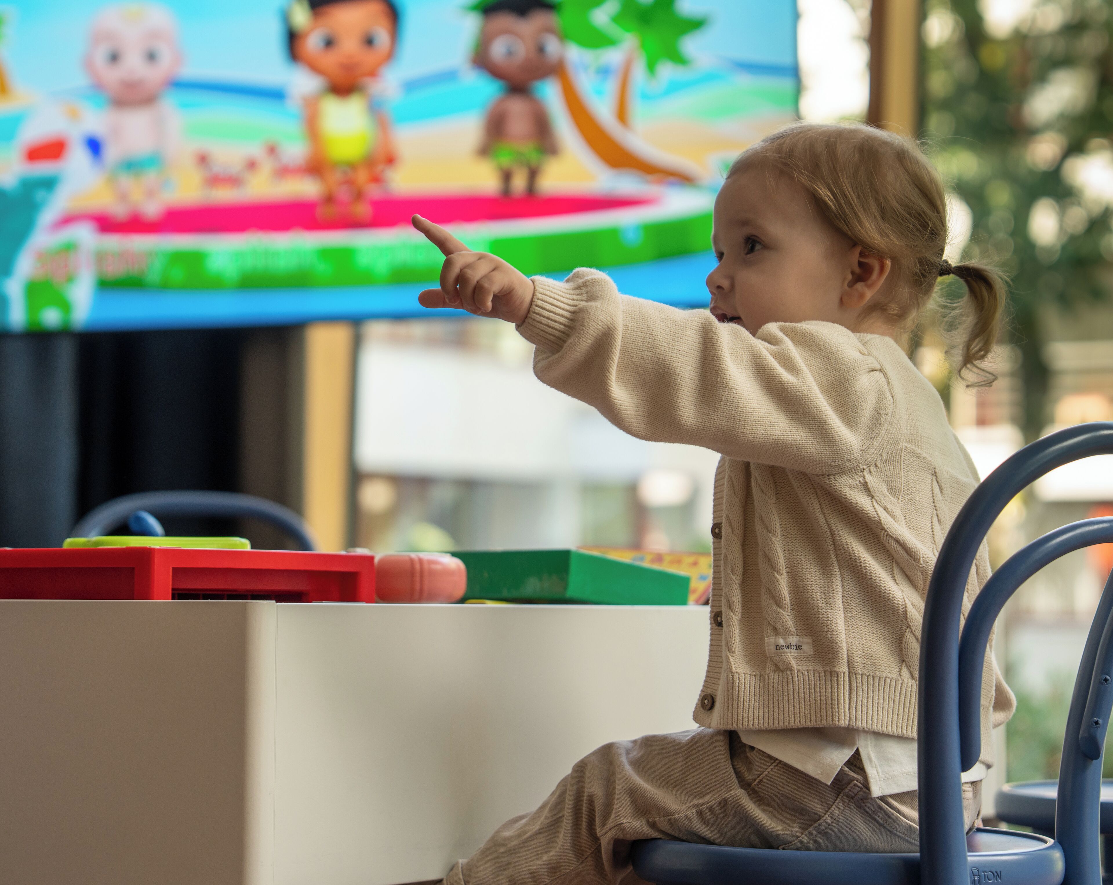 Un niño señalando una pantalla de televisión.