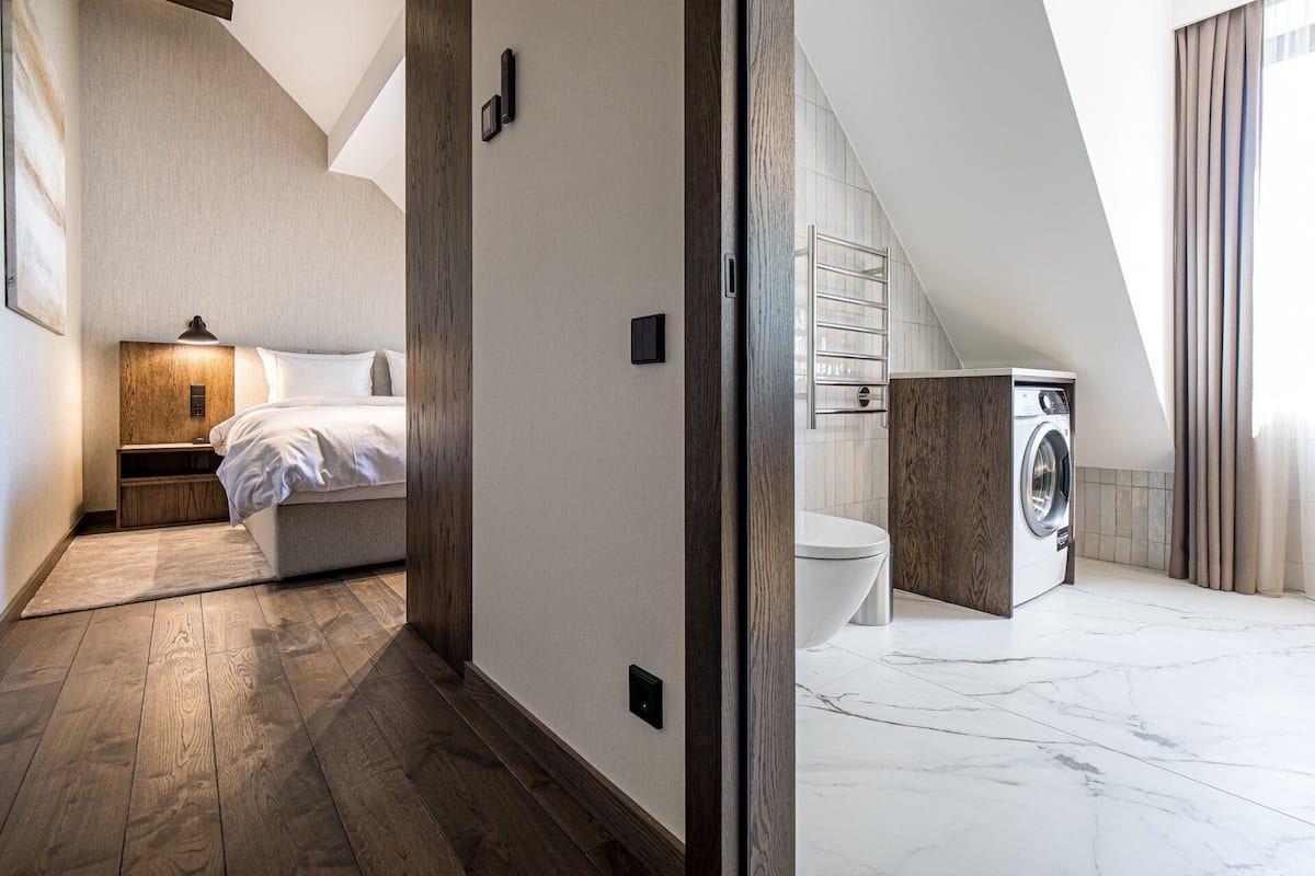 Ein modernes Schlafzimmer mit einem hölzernen Kopfteil, einer Nachttischlampe und einem großen Bett.