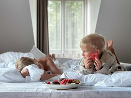Un dormitorio con cama, almohadas y un plato de comida.