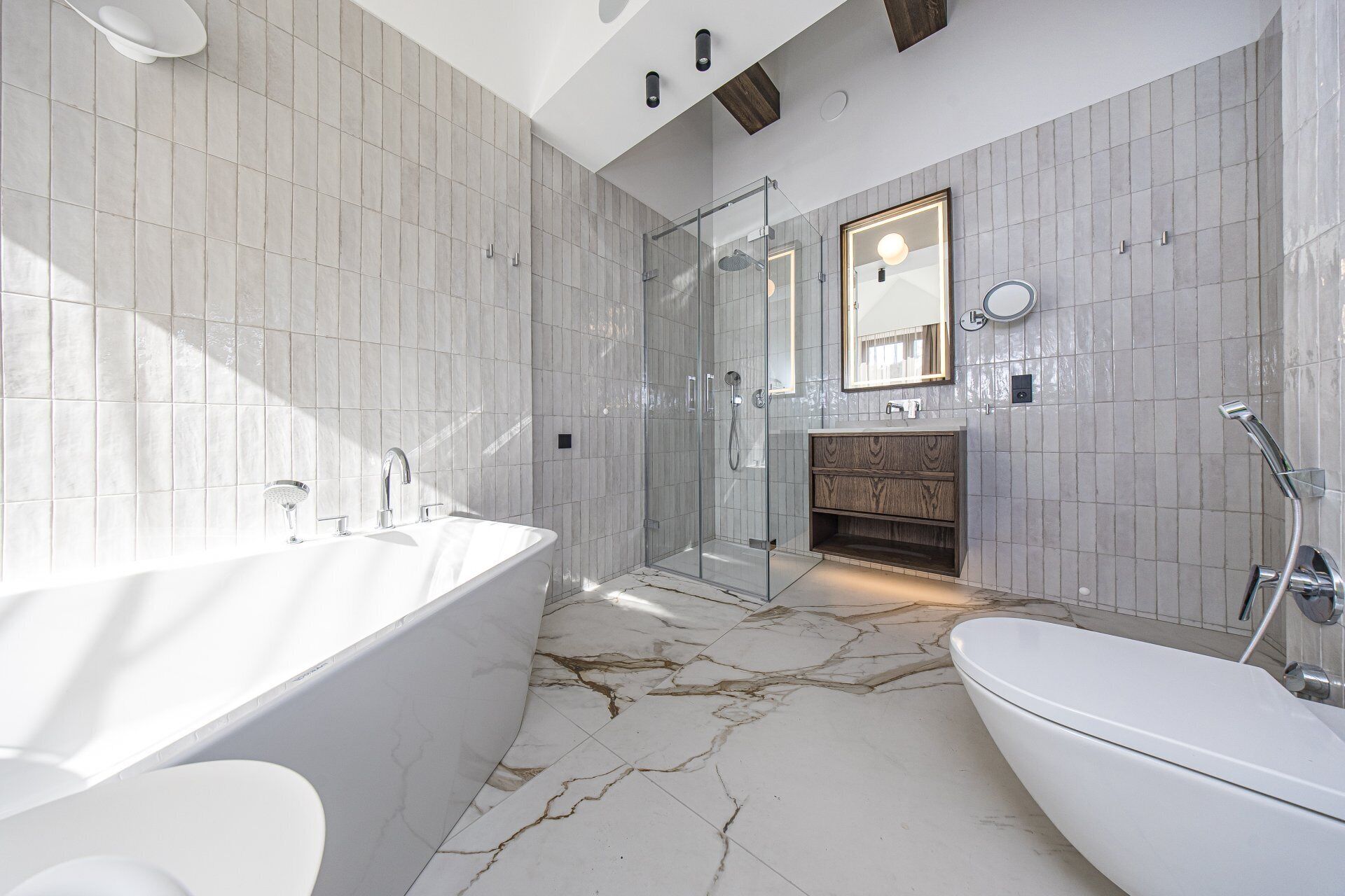 A modern bathroom with a freestanding bathtub, a glass-enclosed shower, and a vanity with a mirror.