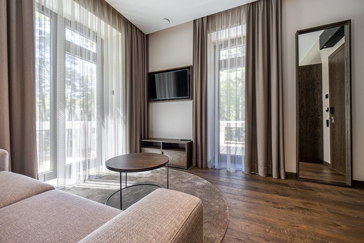 Ein modernes Wohnzimmer mit Flachbildfernseher an der Wand, einem runden Couchtisch und einem Sofa.