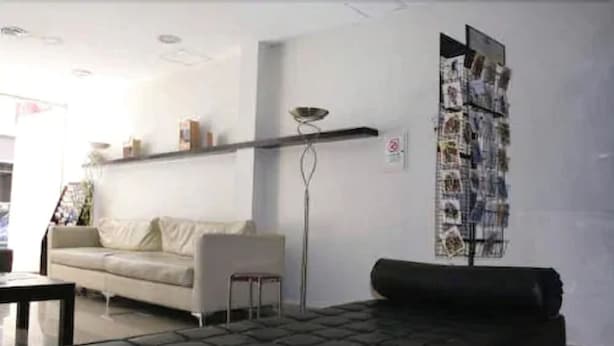 A living room with a sofa, a coffee table, and a floor lamp. - Argentina Tango Hotel (Buenos Aires)