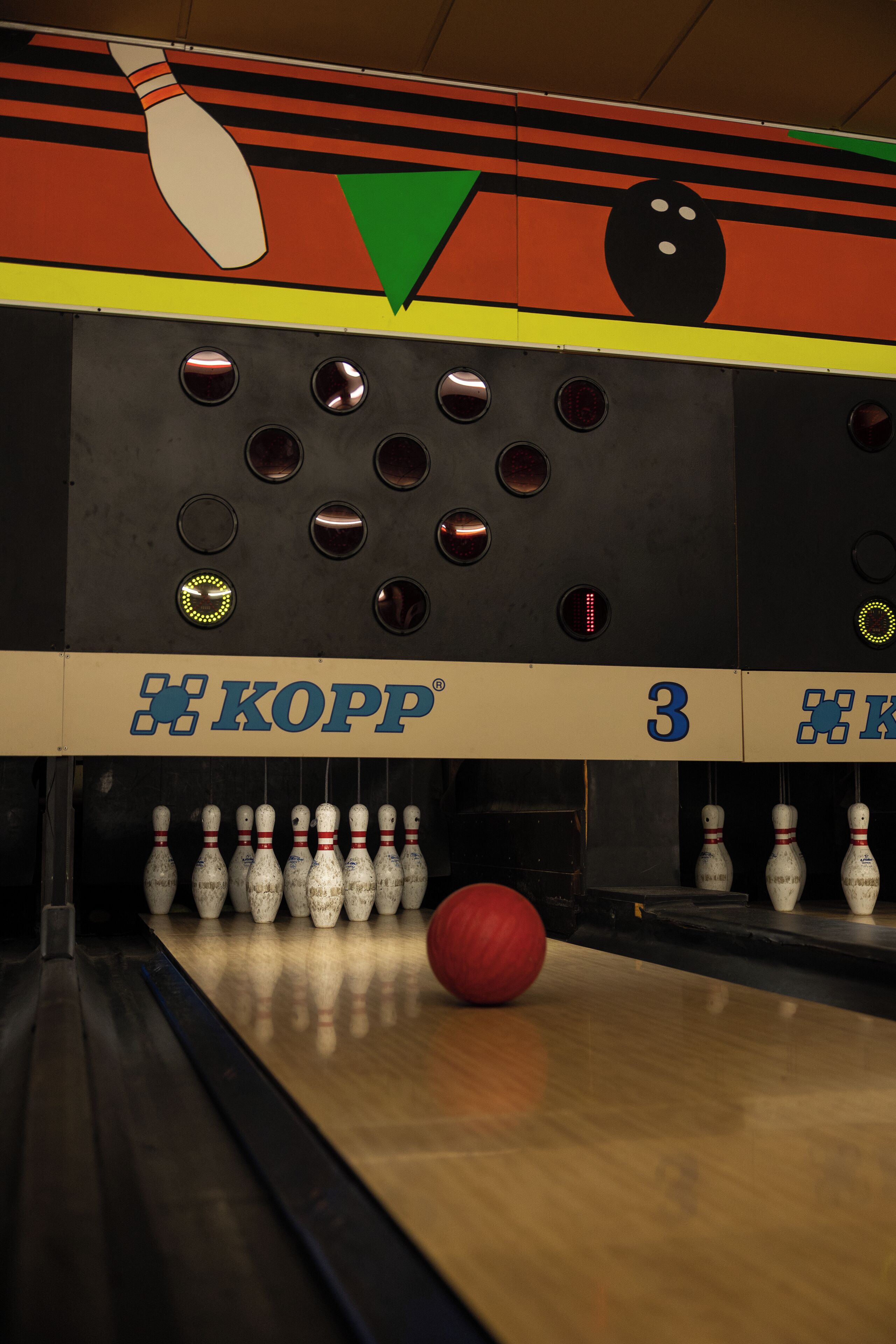A bowling alley with multiple lanes, numbered 3, and a Kopp logo.