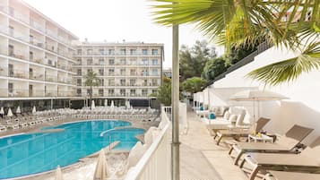 Una piscina al aire libre, sombrillas, tumbonas