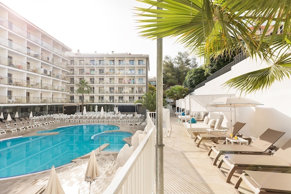 Alberca al aire libre, sombrillas en la alberca y camastros