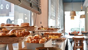 A bakery display with various baked goods, including croissants and pastries, in a café setting. - Hotel LaMorosa (Rimini)