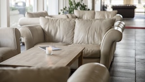 Un espace de détente moderne avec des canapés en cuir et une table basse en bois.