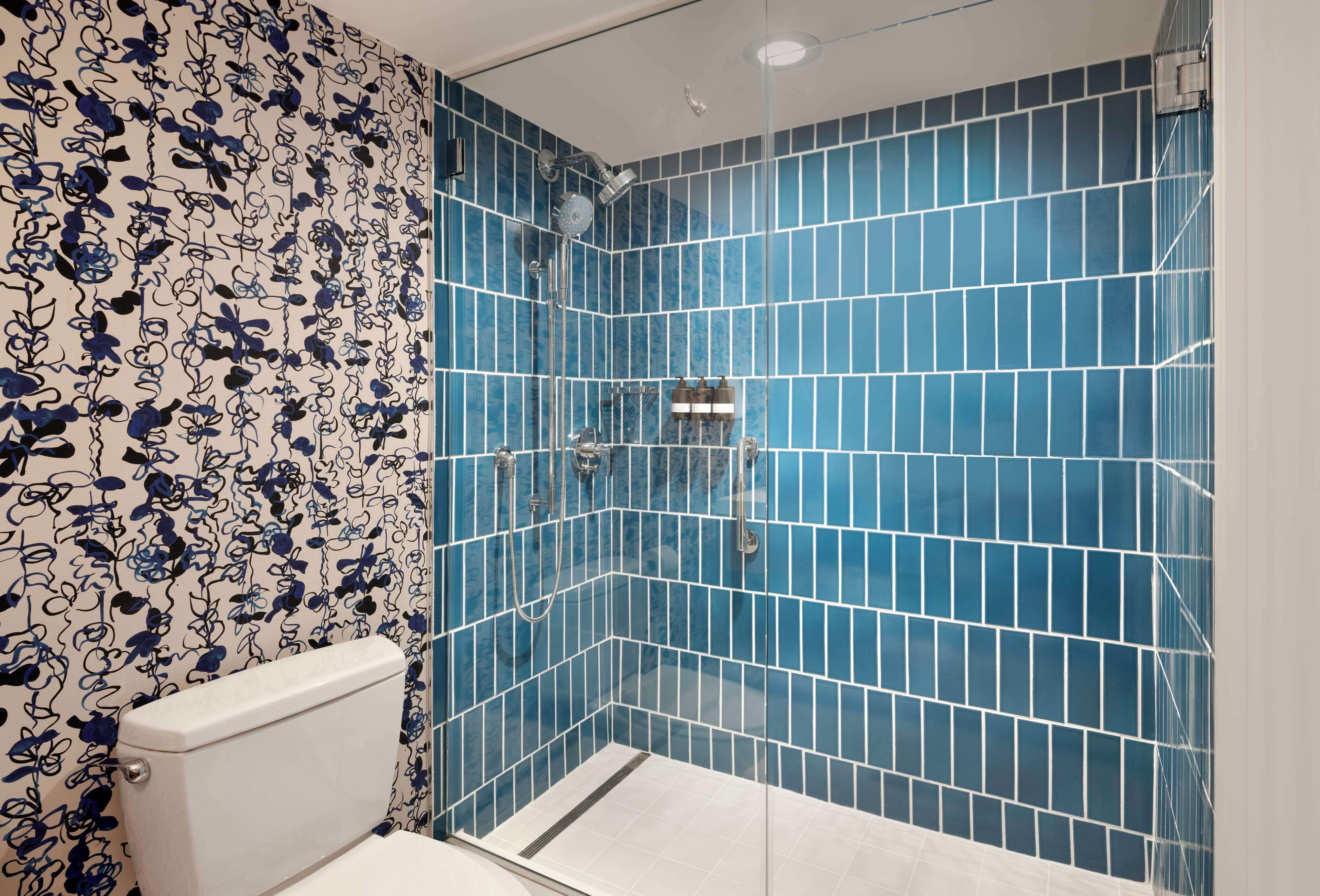 Ein Badezimmer mit blauen Fliesenwänden und einer weißen Toilette.
