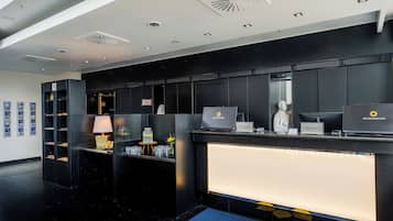 Ein Hotel-Rezeptionsbereich im modernen Design mit einer Rezeption, einem Computer und einem Check-in-Schalter.