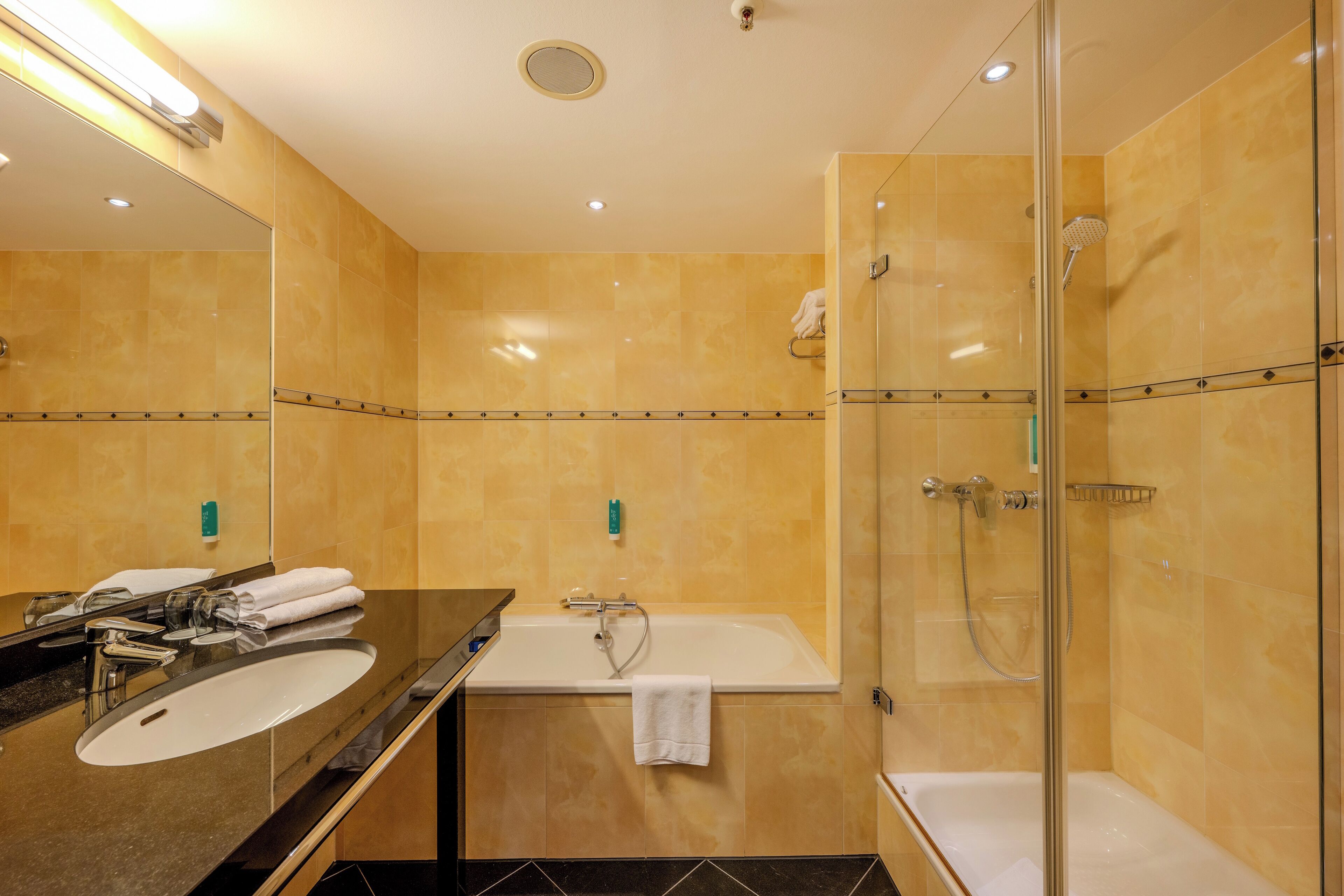 Ein modernes Badezimmer mit einem großen Spiegel, einer Badewanne und einer Duschkabine.