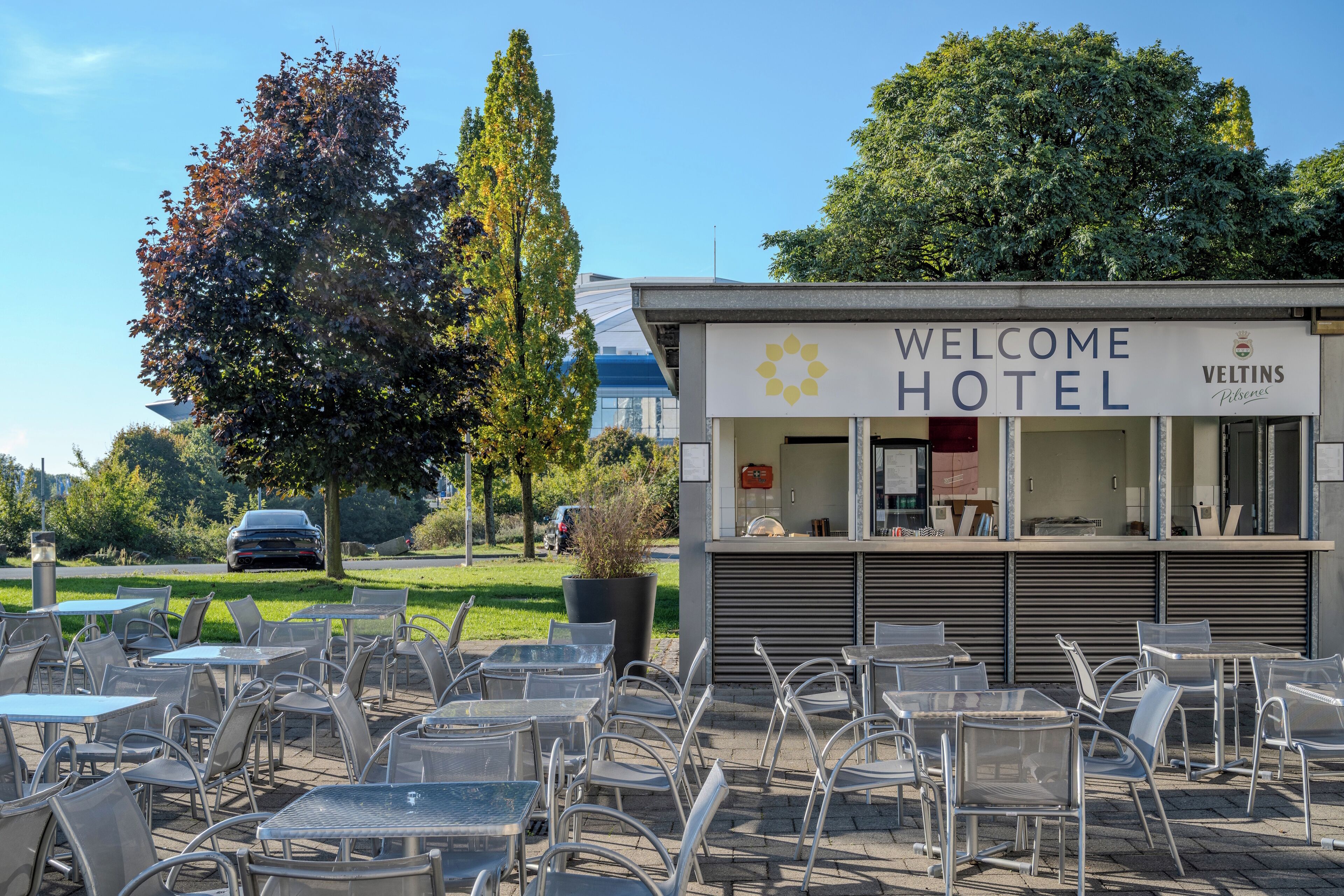 Hotel 'Welcome' con asientos al aire libre y diseño moderno.