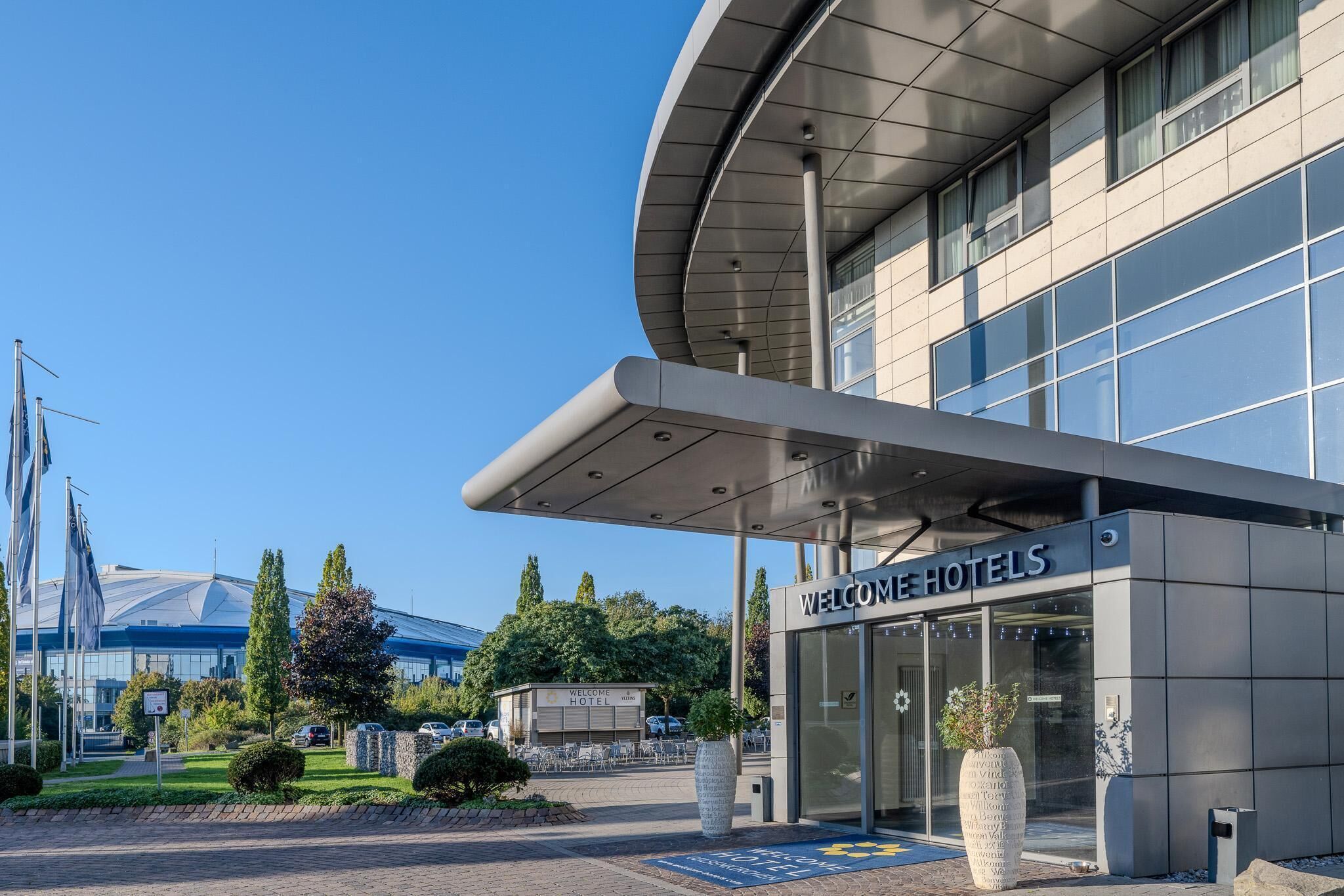 Ein moderner Hotelaufgang mit gewölbter Dachkonstruktion und großen Fenstern.