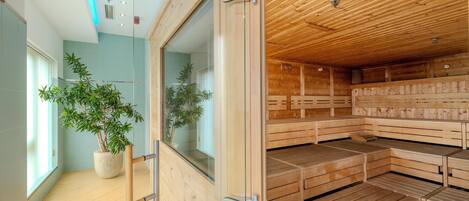 A sauna with wooden benches and a glass door, a potted plant, and a tiled floor.