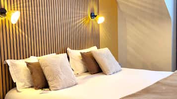 A neatly made bed with multiple pillows and a white headboard with vertical lines.
