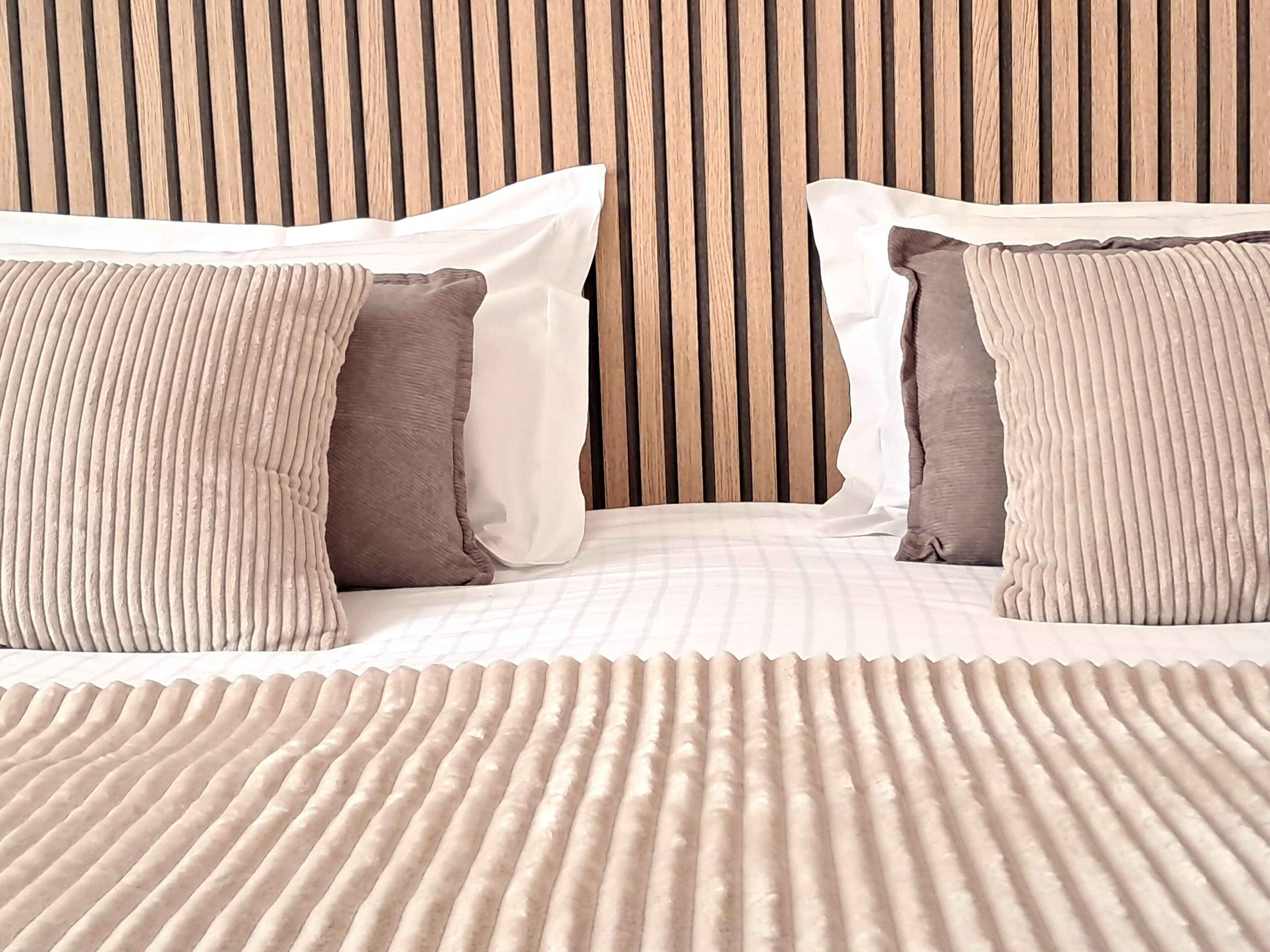 Ein Bett mit einem gestreiften Kopfteil und zwei Kissen.