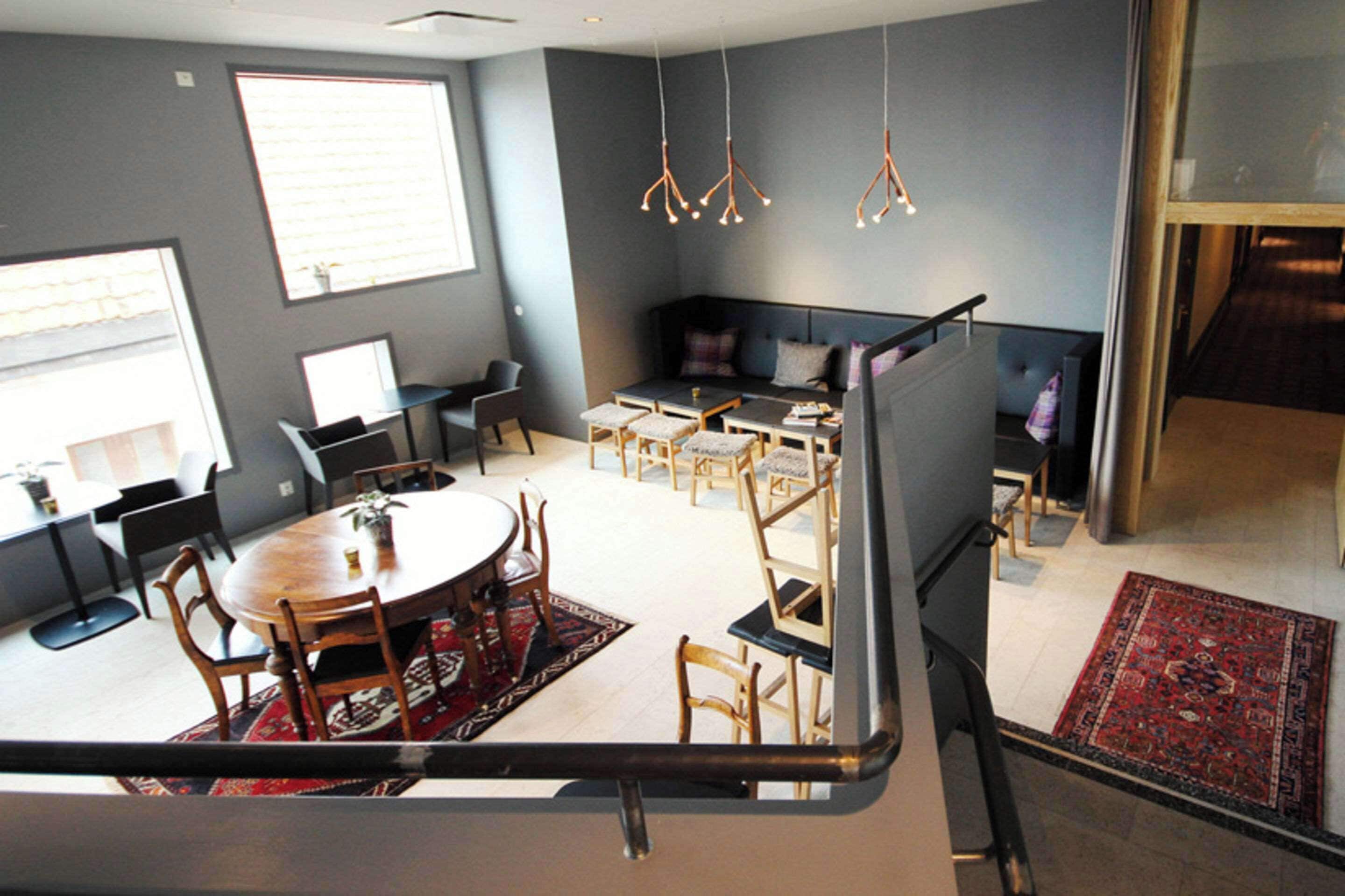 A modern interior with a dining area, seating, and a staircase.