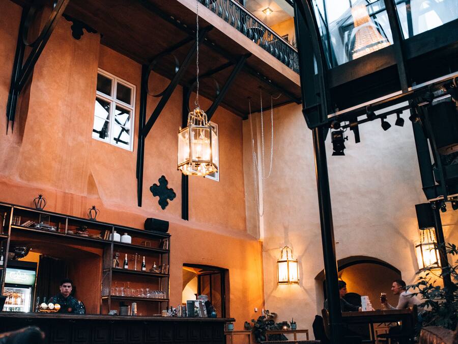 Un interior espacioso con techos altos, un atrio de vidrio y una zona de bar.