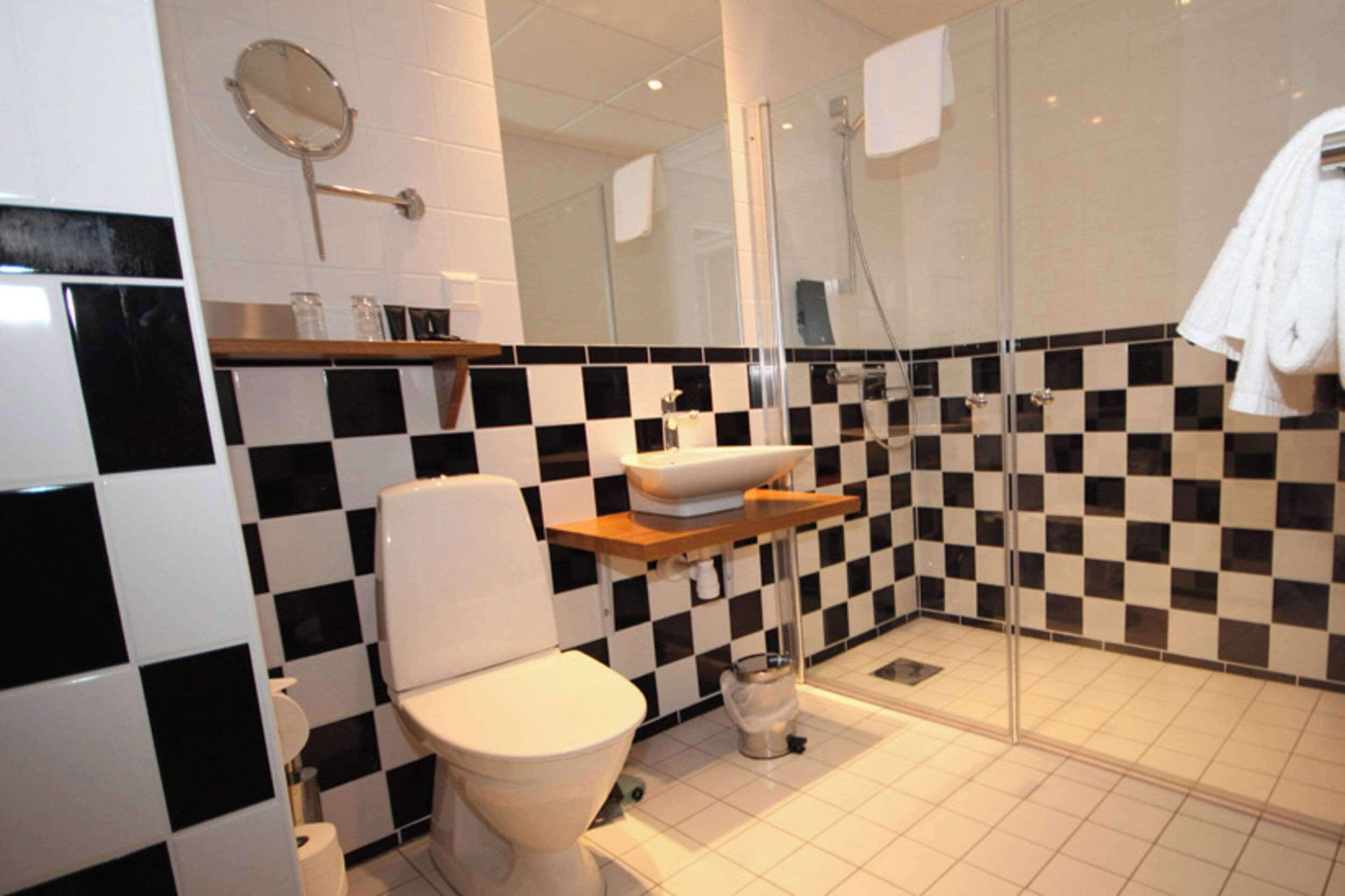 Un baño con inodoro, lavabo y zona de ducha.