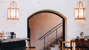 Un interior acogedor con una escalera, muebles de madera y faroles colgantes.