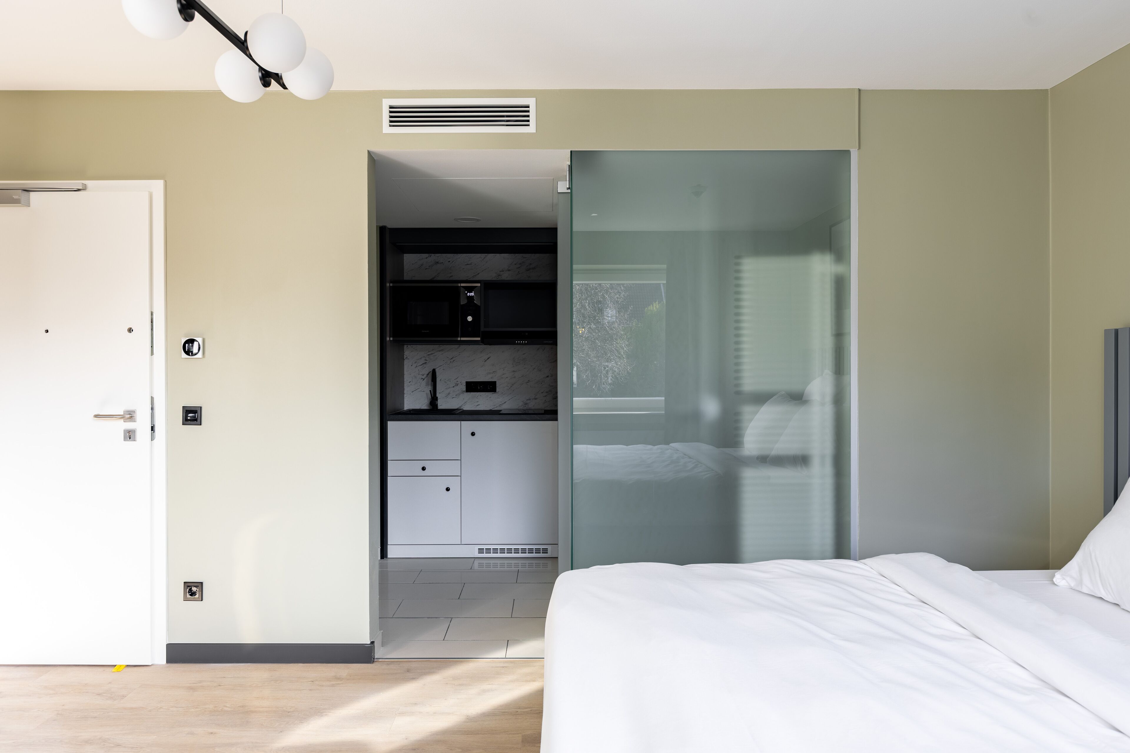 A modern bedroom with a bed, a wardrobe, and a built-in desk.