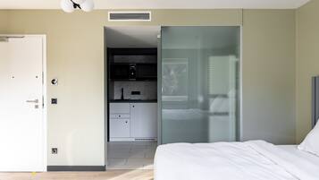 A modern bedroom with a bed, a wardrobe, and a built-in desk.